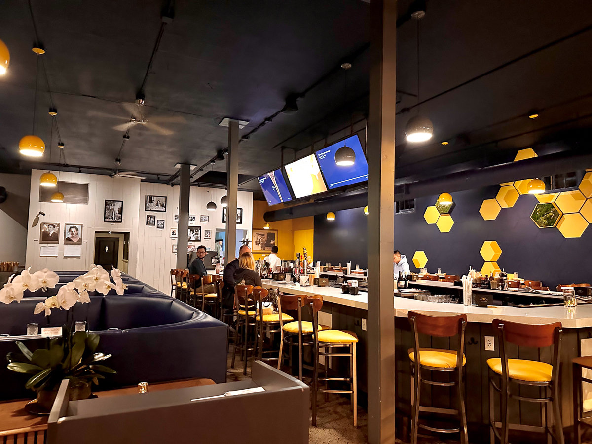 black booths with black wall and honey mural